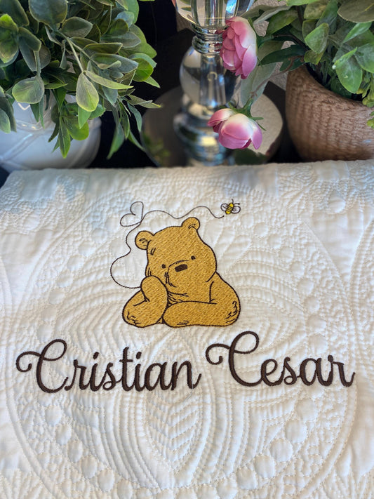 Personalized Storybook Bear Honey Bee Baby Quilt | Custom Name Heirloom Keepsake featuring an embroidered bear and bee design with custom name stitching on a white quilted blanket.