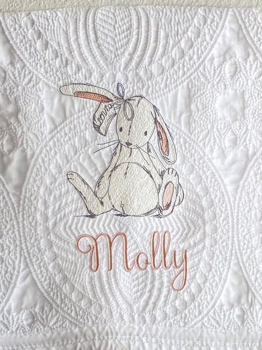 Close-up of Personalized Sketch Bunny Rabbit Baby Quilt | Custom Name Heirloom Keepsake Blanket featuring an embroidered bunny sketch and the name Molly in soft pastel thread on a textured white quilt background.