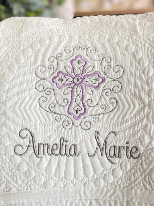 Personalized Lavender Filigree Cross Baby Quilt | Custom Name Christening Heirloom Blanket for Girls featuring intricate lavender and gray embroidery with the name Amelia Marie on a white quilted fabric.