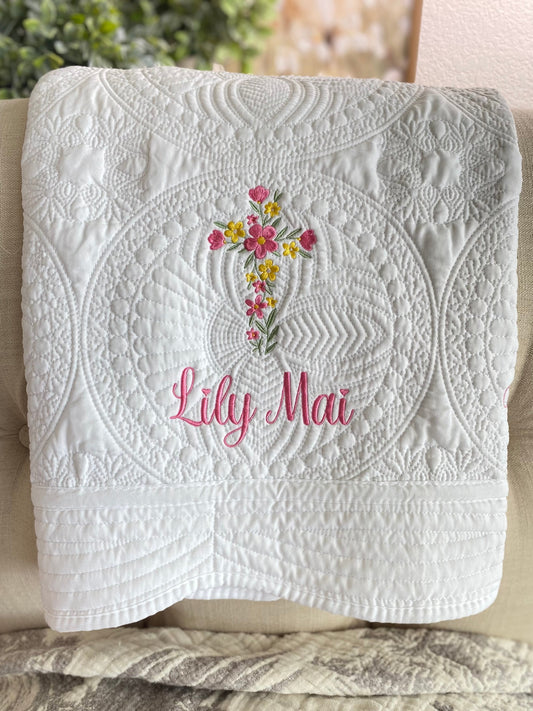 Personalized Floral Cross Baptism Baby Quilt | Custom Name Christening Heirloom Blanket for Girls featuring intricate white quilting with a floral cross and pink embroidered name Lily Mai.