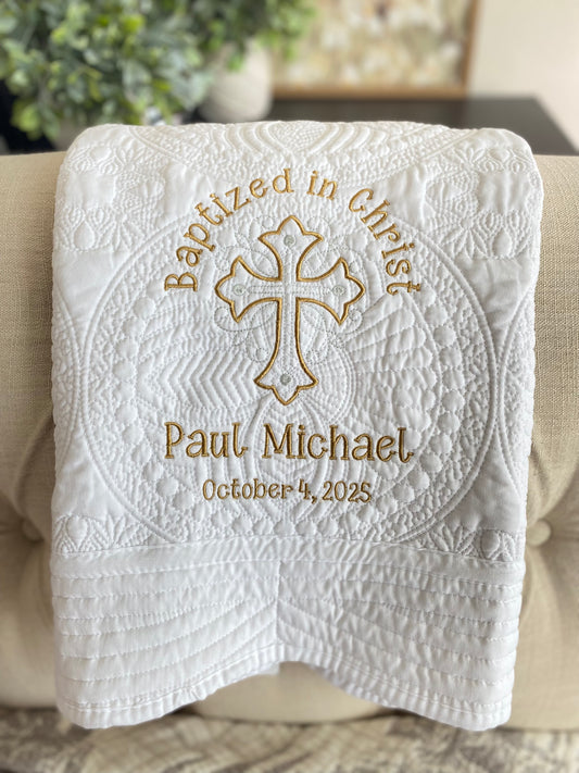 Personalized Baptized in Christ Ornate Cross Baby Quilt | Custom Name & Date Christening Heirloom Blanket with gold embroidered cross, name Paul Michael, and baptism date October 4, 2025, on a white quilted background.