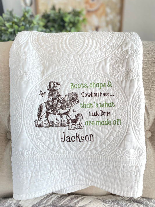 Personalized Little Cowboy on Horse Baby Quilt | Custom Name Heirloom Blanket for Boys featuring detailed embroidery of a cowboy on a horse with a dog and custom name Jackson on a white quilted blanket.