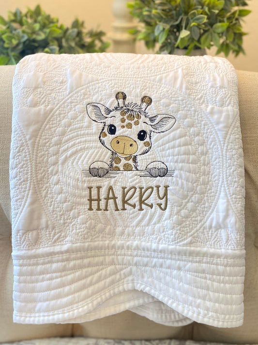 Close-up of a white quilt featuring a cute embroidered giraffe and the name Hakky, showcasing the Personalized Embroidered Giraffe Baby Quilt | Custom Name Heirloom Blanket as a charming handmade baby shower and newborn gift.