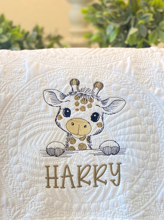Personalized Embroidered Giraffe Baby Quilt | Custom Name Heirloom Blanket featuring an adorable embroidered giraffe with the custom name "Harry" on a white quilted background.