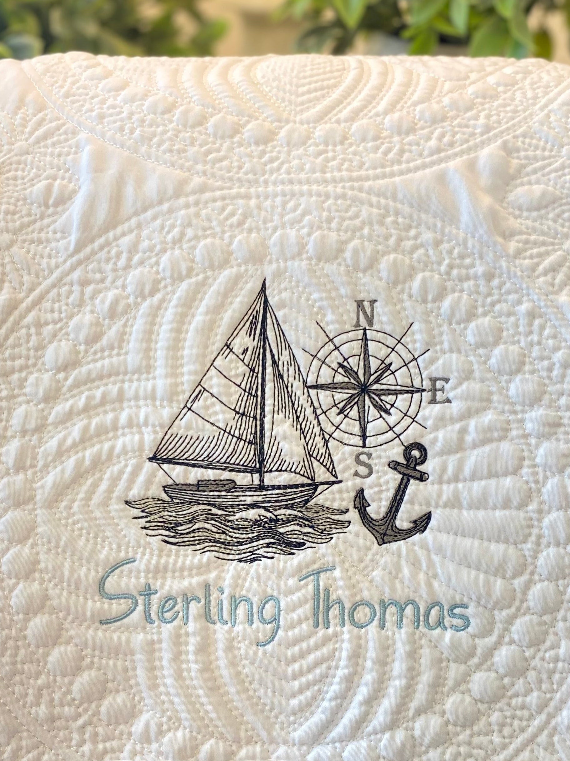 Personalized Embroidered Sailboat Compass & Anchor Baby Quilt | Custom Name Heirloom Blanket featuring detailed sailboat, compass, and anchor embroidery with a custom name on a soft quilted fabric.
