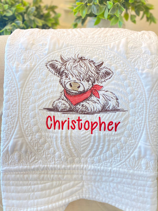 White quilt featuring detailed embroidery of a Highland cow wearing a red bandana above the personalized name Christopher, showcasing the Personalized Embroidered Highland Cow Baby Quilt | Custom Name Heirloom Blanket design.