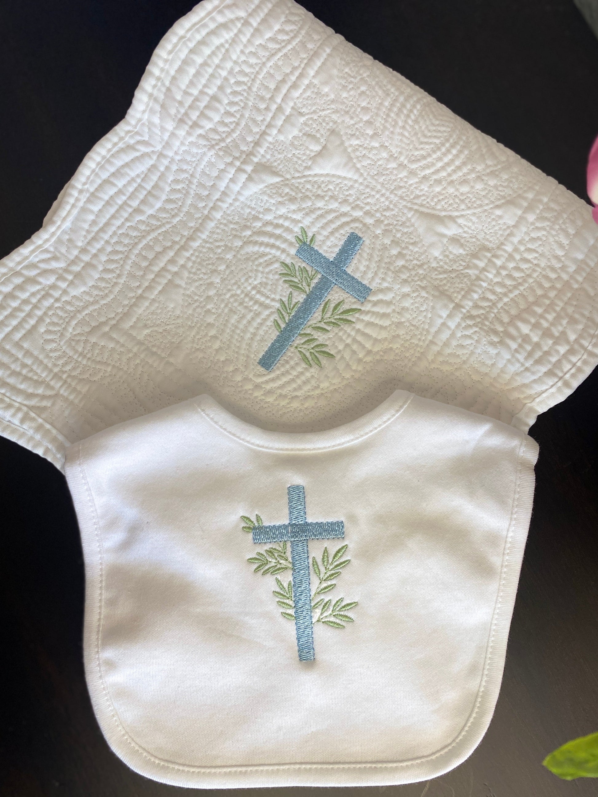 Personalized Laurel Branch Cross Baptism Gift Set | Custom Quilt Bib & Burp Cloth Christening Heirloom featuring white quilted fabric and bib with embroidered blue cross and green laurel branches.