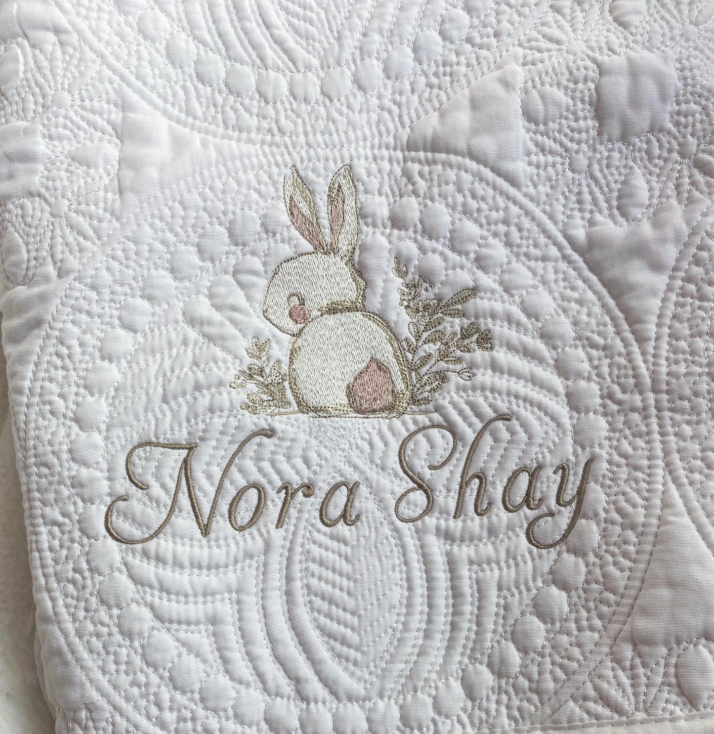 Personalized Embroidered Bunny Rabbit Baby Quilt | Whimsical Heirloom Keepsake | Custom Name Blanket featuring delicate bunny embroidery and custom name stitching on a textured white quilt.