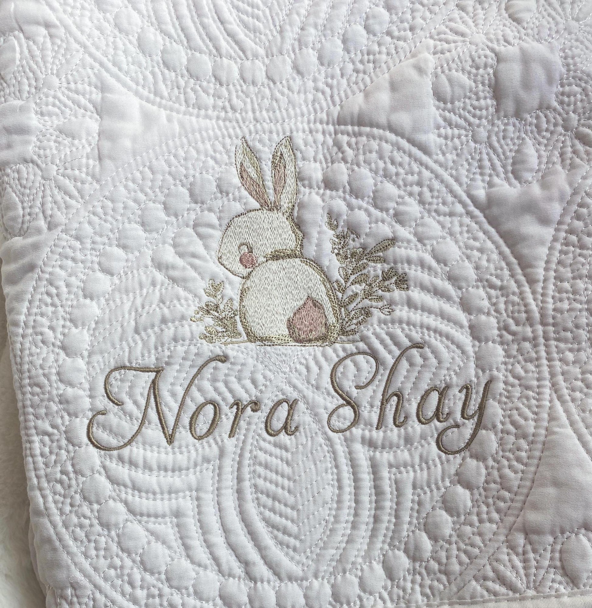 Personalized Embroidered Bunny Rabbit Baby Quilt | Whimsical Heirloom Keepsake | Custom Name Blanket featuring delicate bunny embroidery and custom name stitching on a textured white quilt.