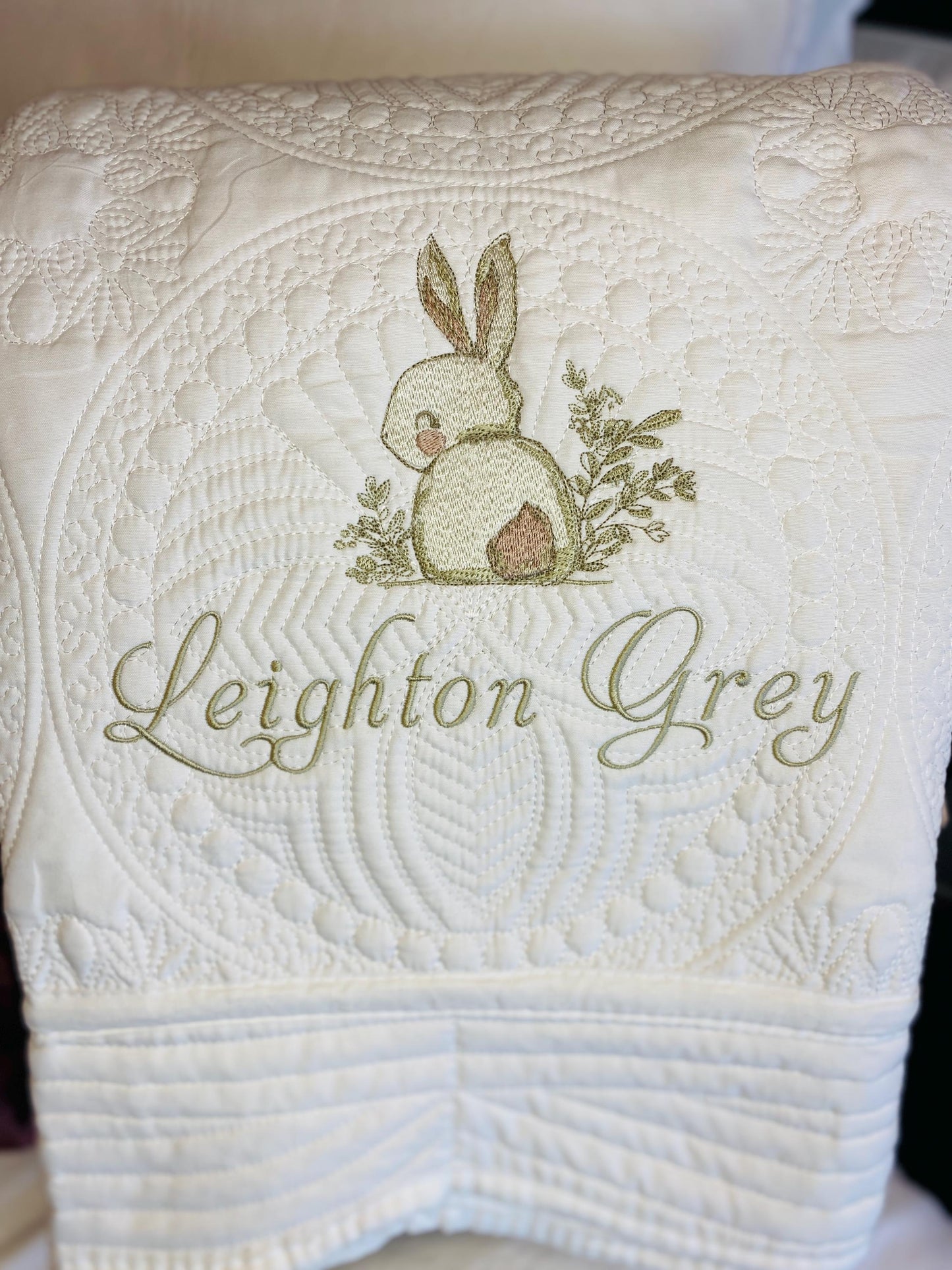 Personalized Embroidered Bunny Rabbit Baby Quilt | Whimsical Heirloom Keepsake | Custom Name Blanket featuring a delicate embroidered bunny with greenery and custom name in elegant script on a textured cream quilt.