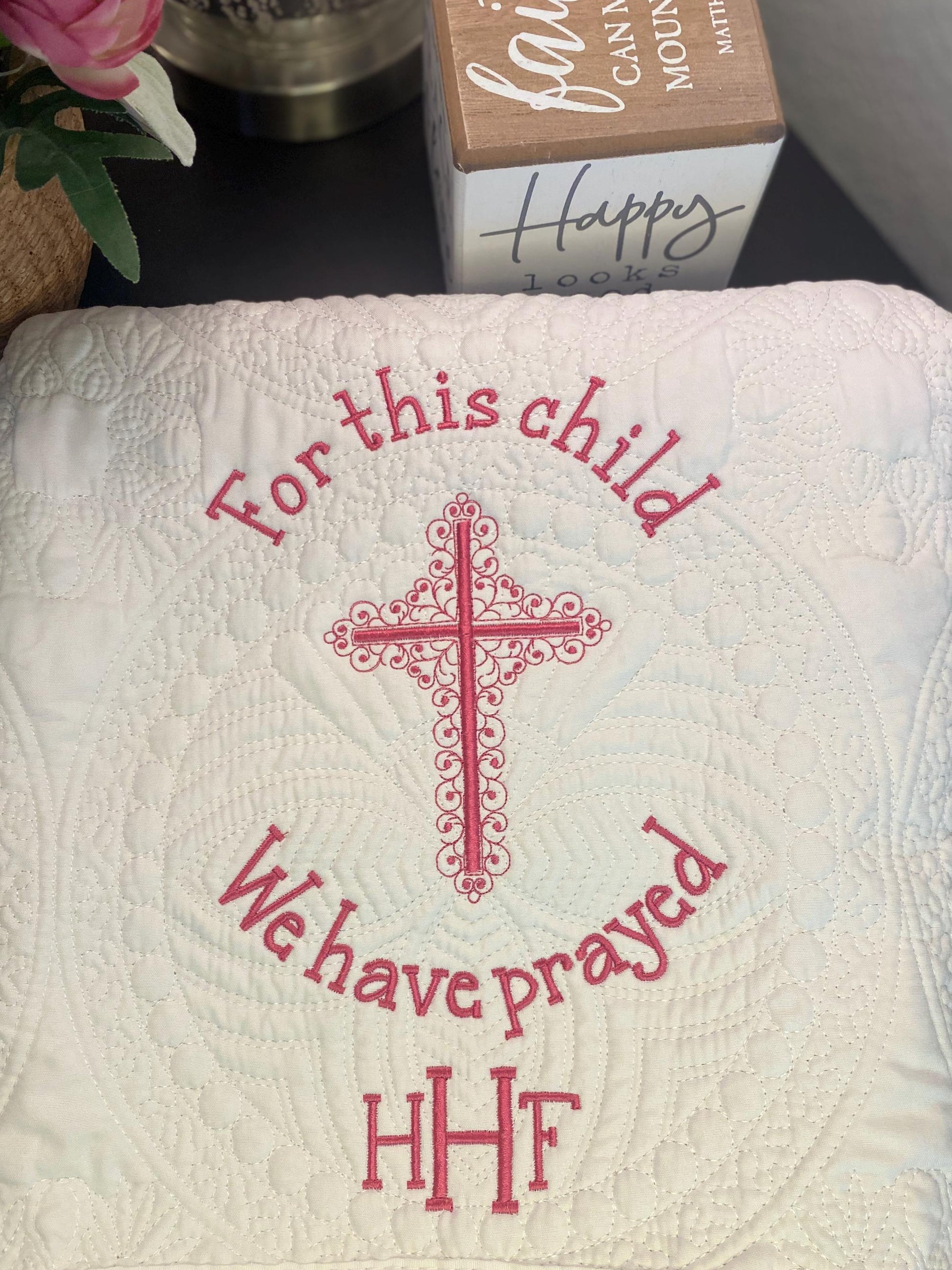 For This Child We Have Prayed" Cross Baby Quilt | Custom Embroidered Baptism Heirloom Blanket featuring an intricate pink cross and delicate quilting patterns on a soft white fabric.