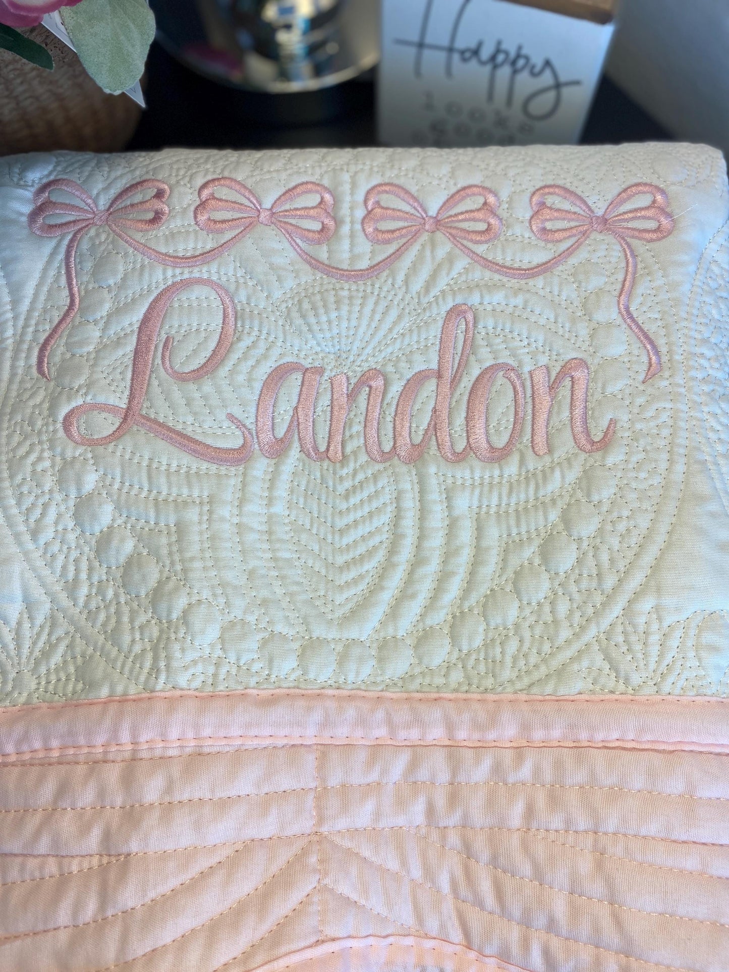 Personalized Pink Bow Baby Quilt | Custom Name Heirloom Blanket for Girls featuring delicate pink embroidered bows and the name Landon on a soft quilted fabric, perfect for a newborn gift.