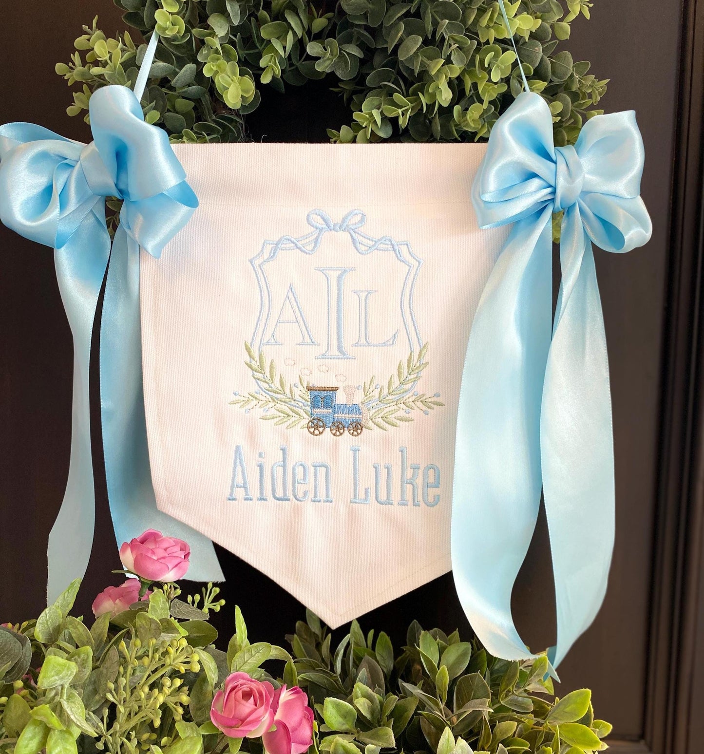 Personalized Embroidered Baby Birth Announcement Banner | Hospital Door Sign | Choose Your Design featuring a soft fabric banner with blue embroidered initials, name, decorative train, and blue satin bows.