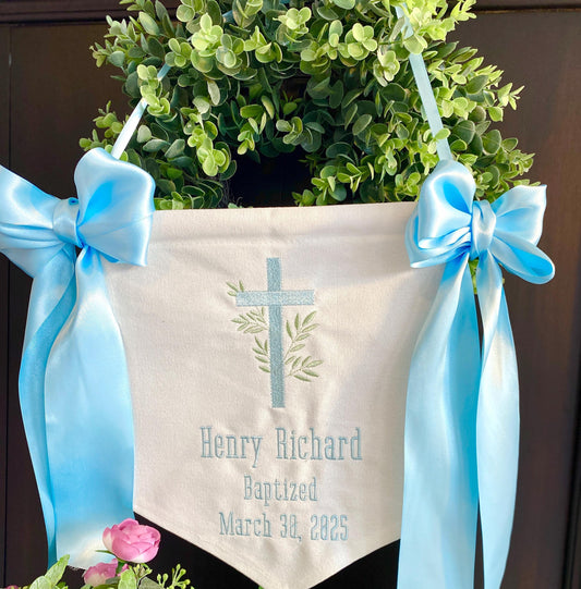 Personalized Embroidered Baptism & Christening Banner | Custom Name Vine Cross Keepsake hanging with light blue ribbons, white fabric, embroidered cross and green vine design, custom text with name and baptism date.