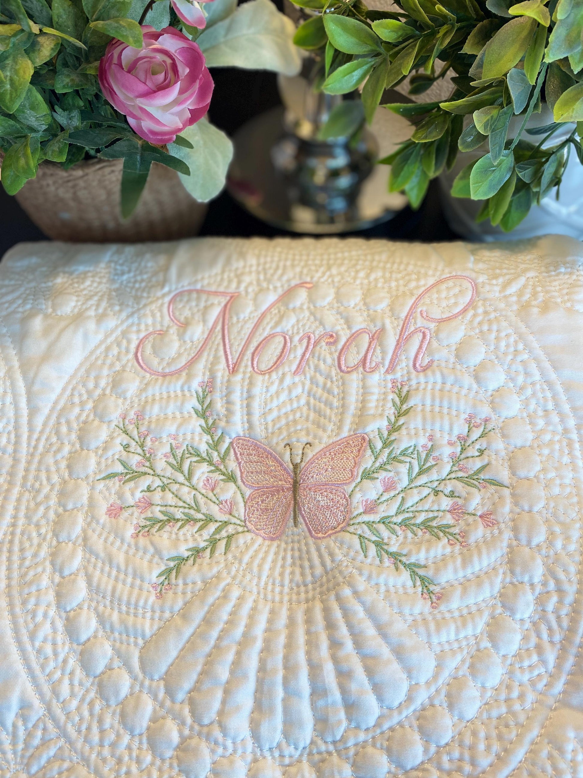 Personalized Pink Butterfly & Botanical Baby Quilt | Custom Name Heirloom Blanket for Girls featuring delicate pink butterfly embroidery and soft green botanical accents with the name Norah.
