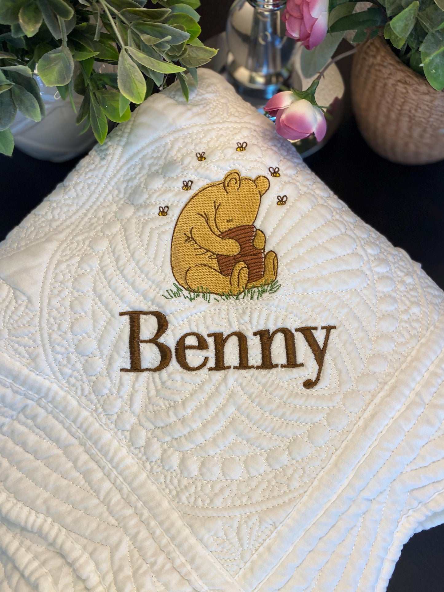 Personalized Storybook Bear Honey Pot Baby Quilt | Custom Name Heirloom Keepsake featuring a cozy quilted baby blanket with an embroidered bear holding a honey pot and custom name "Benny" surrounded by gentle floral decor.