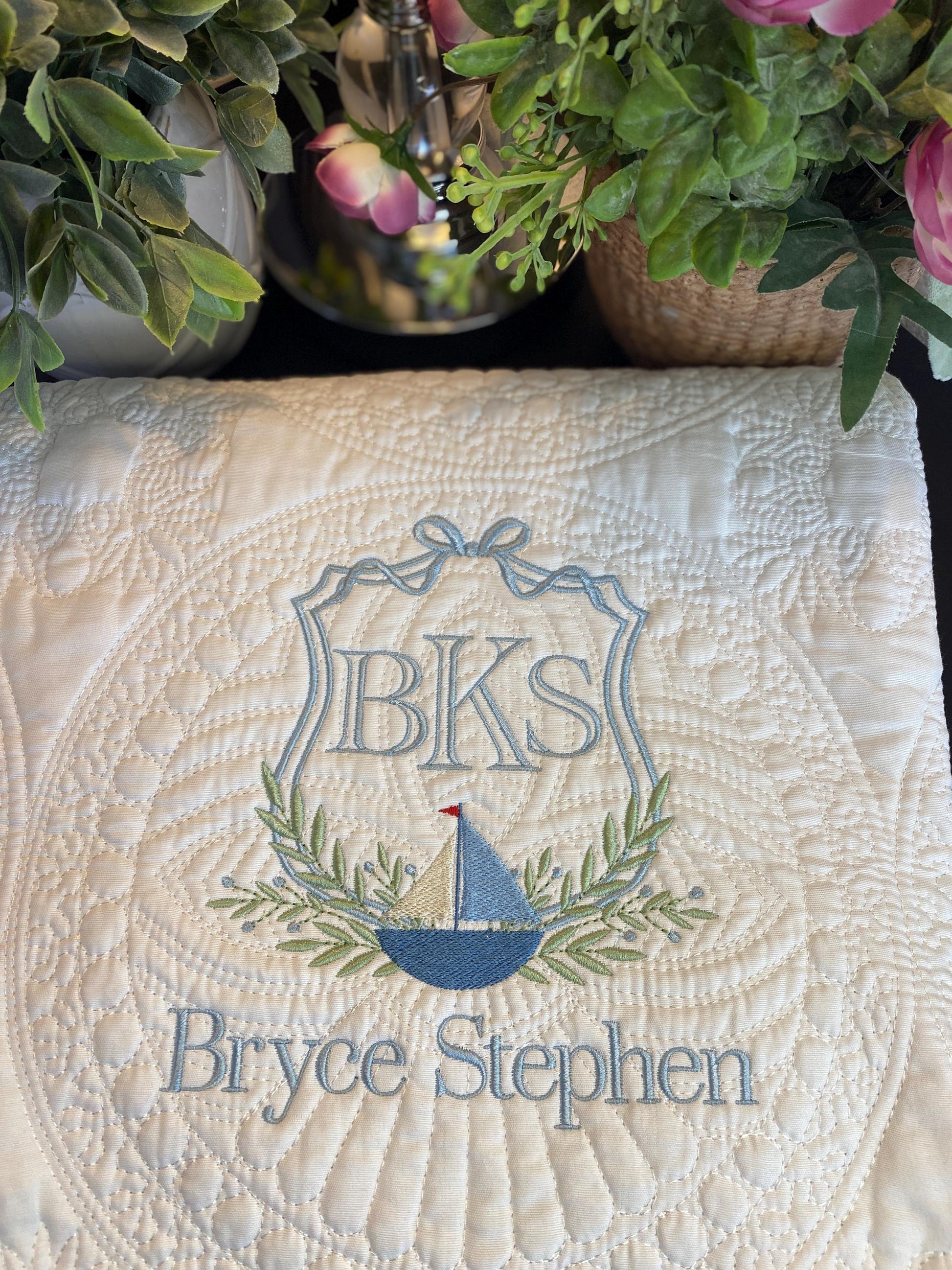 Personalized Sailboat Crest Monogram Baby Quilt | Custom Embroidered Heirloom Blanket for Boys featuring a detailed sailboat, monogram initials BKS, and the name Bryce Stephen in soft blue and green embroidery.