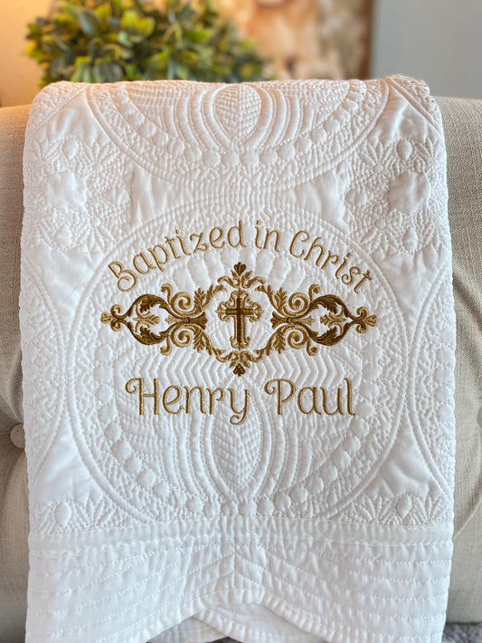 Personalized Baptized in Christ Scrollwork Cross Baby Quilt | Custom Embroidered Christening Heirloom Blanket with delicate gold embroidery and ornate cross design on soft white fabric.