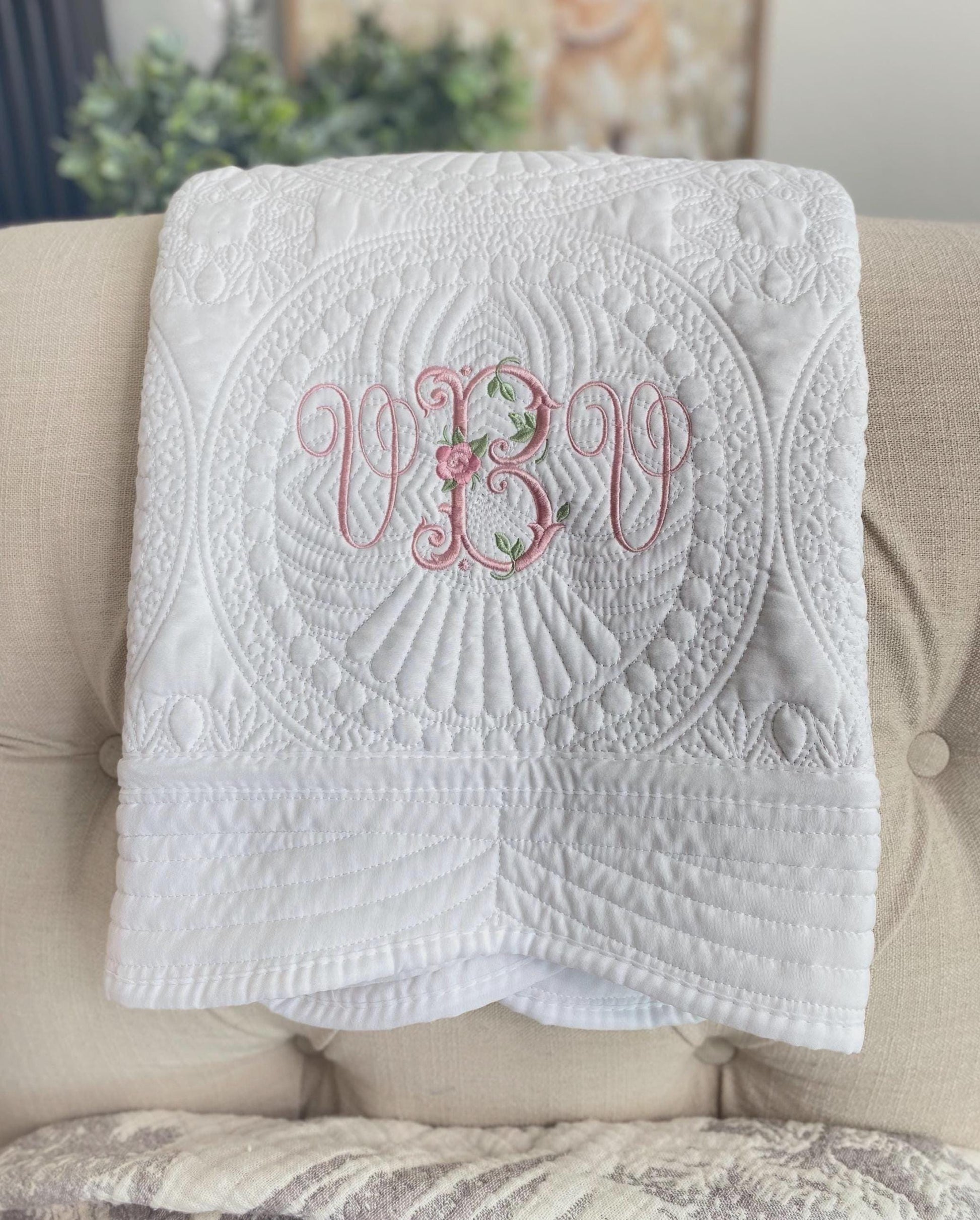 Personalized Vintage Rose Monogram Baby Quilt | Custom Embroidered Heirloom Blanket with delicate pink floral monogram on a white quilted fabric, perfect newborn or baby shower gift.