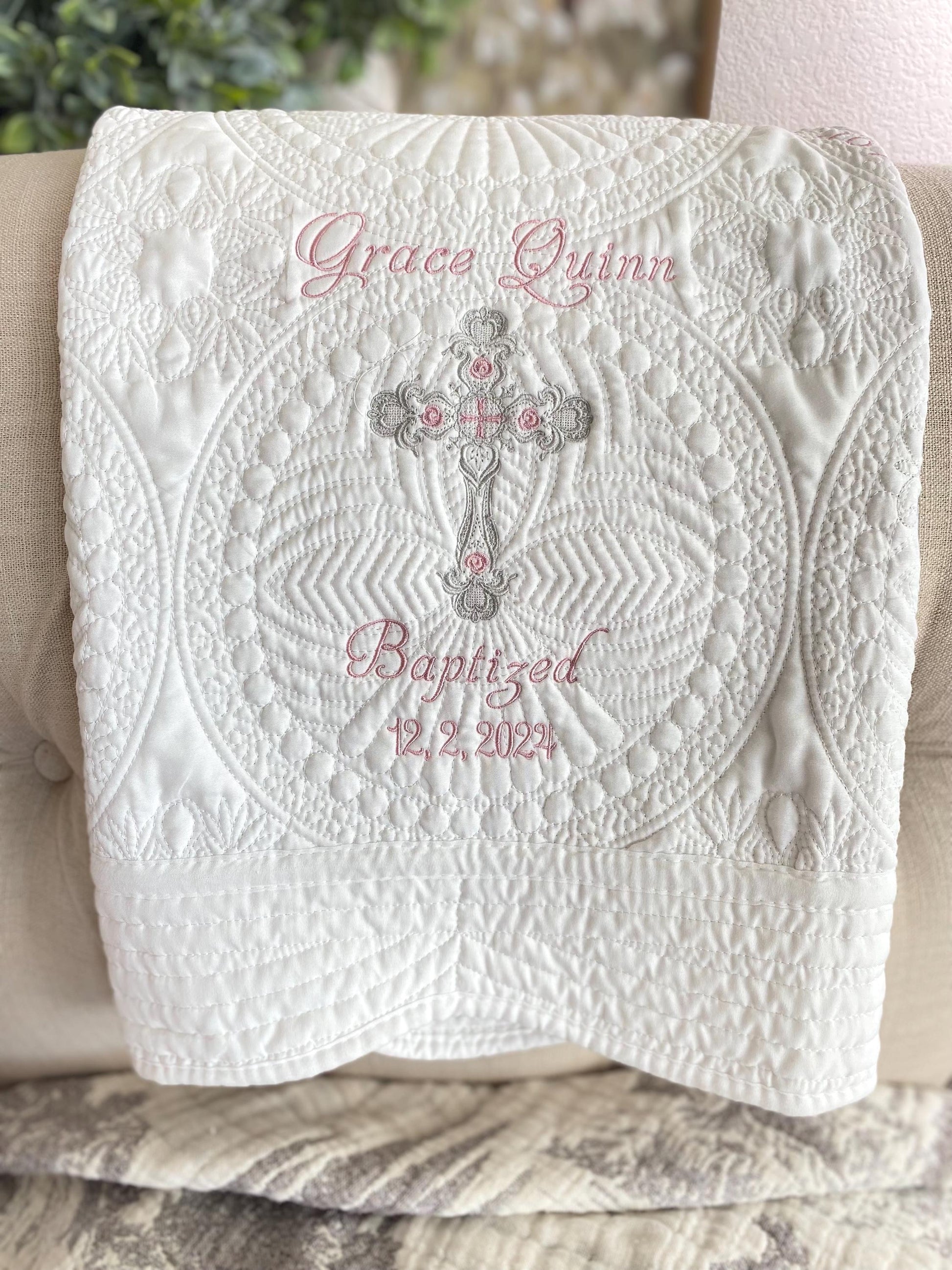 Personalized Baptism Baby Quilt | Custom Cross Christening Heirloom Blanket featuring intricate white quilting with delicate pink embroidery of a name, cross, and baptism date.