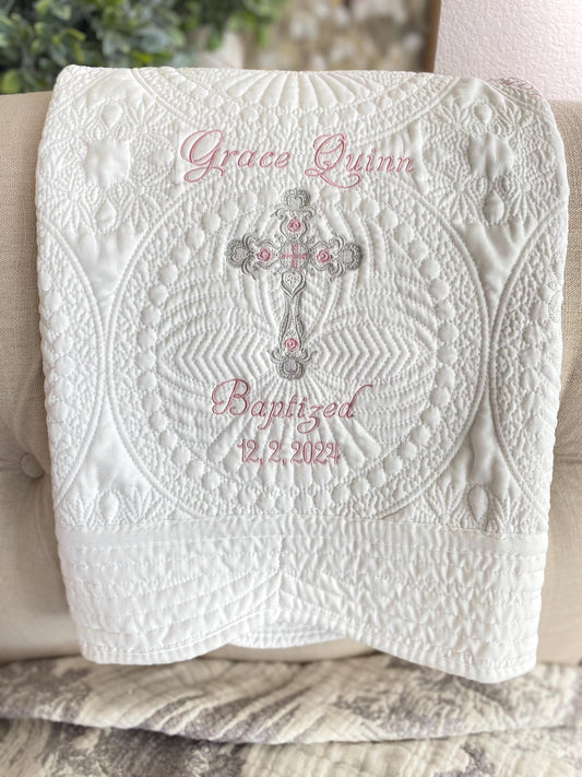 Personalized Baptism Baby Quilt | Custom Cross Christening Heirloom Blanket featuring intricate white quilting with delicate pink embroidery of a name, cross, and baptism date.