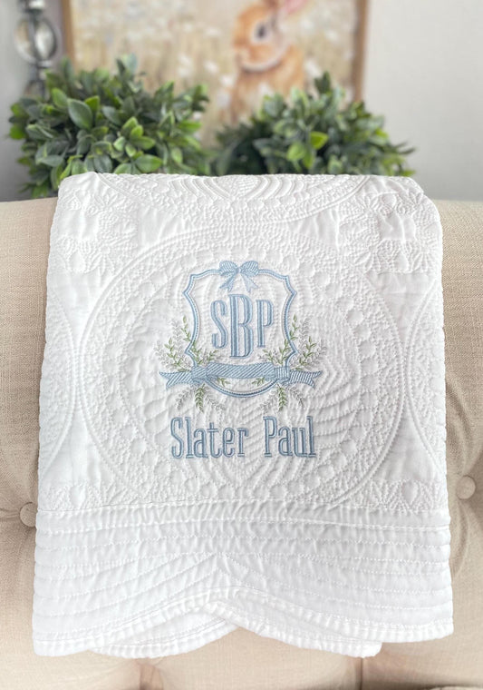Personalized Vine Crest Monogram Baby Quilt | Custom Embroidered Heirloom Keepsake featuring delicate blue and green embroidery on a textured white quilt, perfect as an heirloom baby gift.
