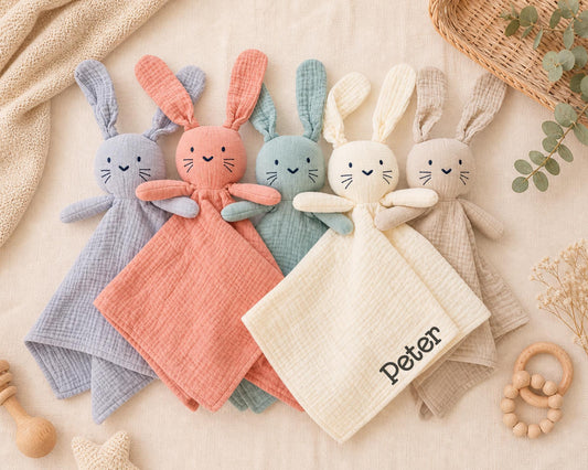 Personalized Bunny Lovey | Organic Muslin Baby Security Blanket | Custom Embroidered Name in soft pastel colors, featuring embroidered faces and one with the name Peter.
